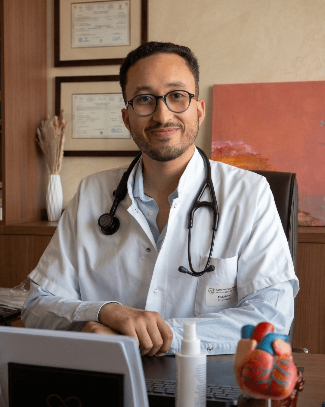 Dr. Zakaria Wakrim en blouse blanche à son bureau de consultation, cardiologue à Dcheira Agadir